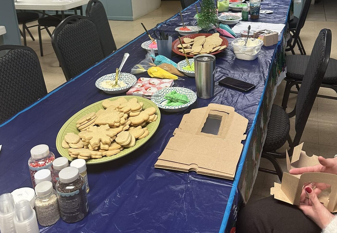 christmas cookie decorating station on a blue tablecloth